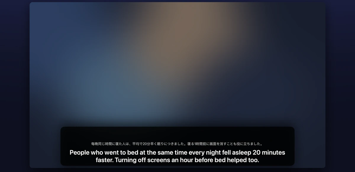 A Mac playing a video, with a subtitle overlay at the bottom: the Japanese original in small grey text and the English translation in white below it.